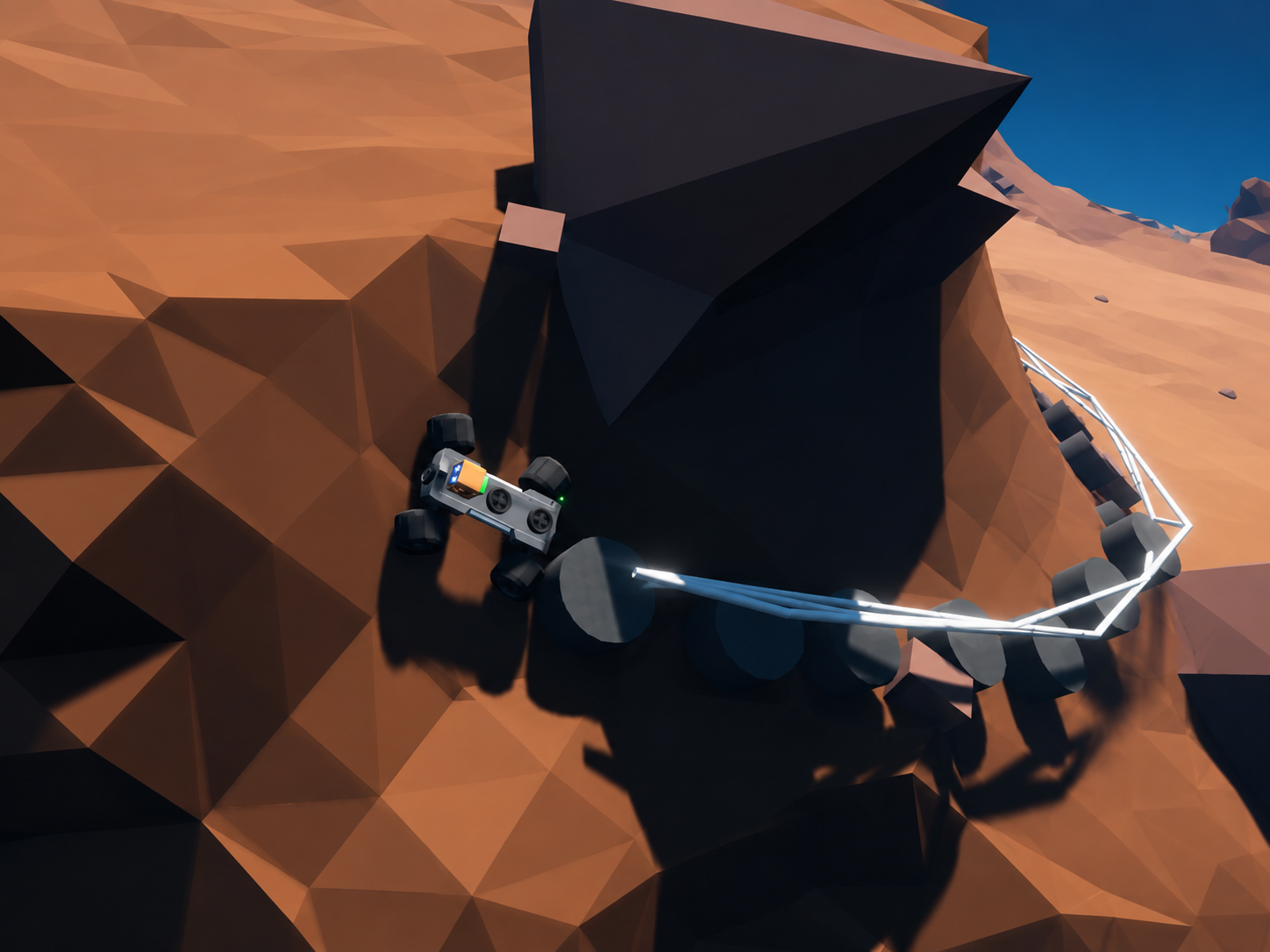 An aerial view of the rover in a rust-orange canyon, tethered by a glowing cable to an anchor point